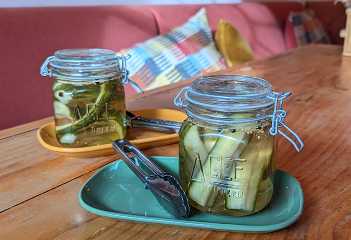 Community Burgers pickle spears served in jars